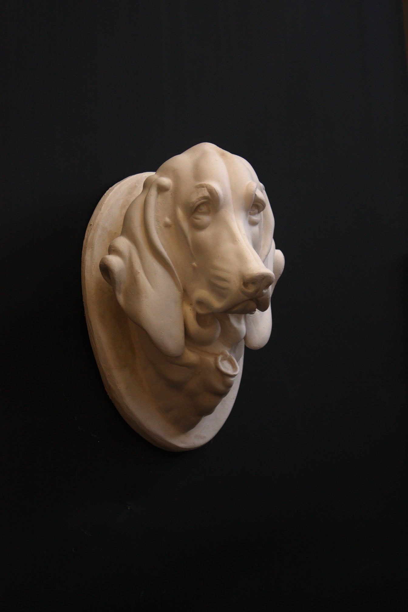 photo of a sculpture of a dog head on a black background 