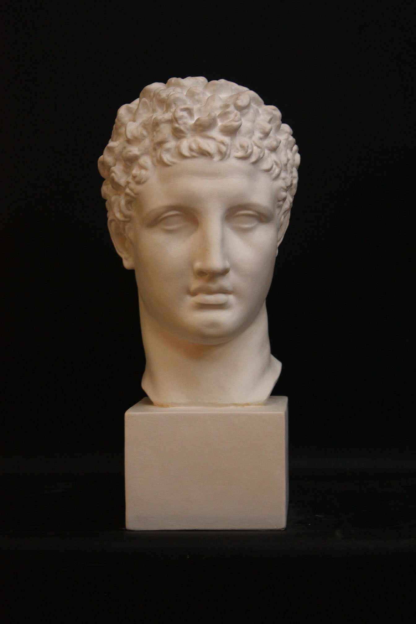 Photo of a sculpture of Hermes head on a black background