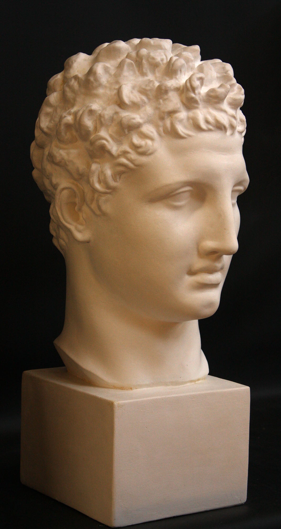 Photo of a sculpture of Hermes head on a black background