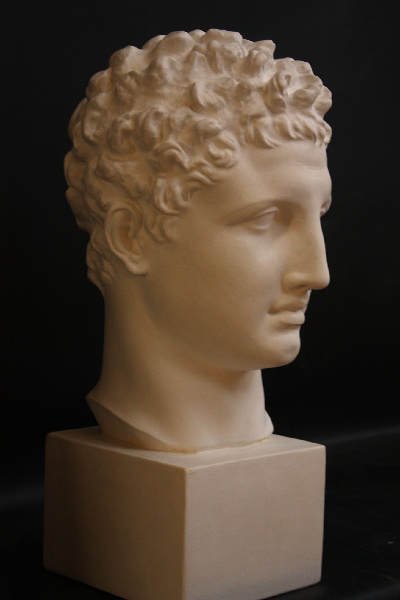 Photo of a sculpture of Hermes head on a black background