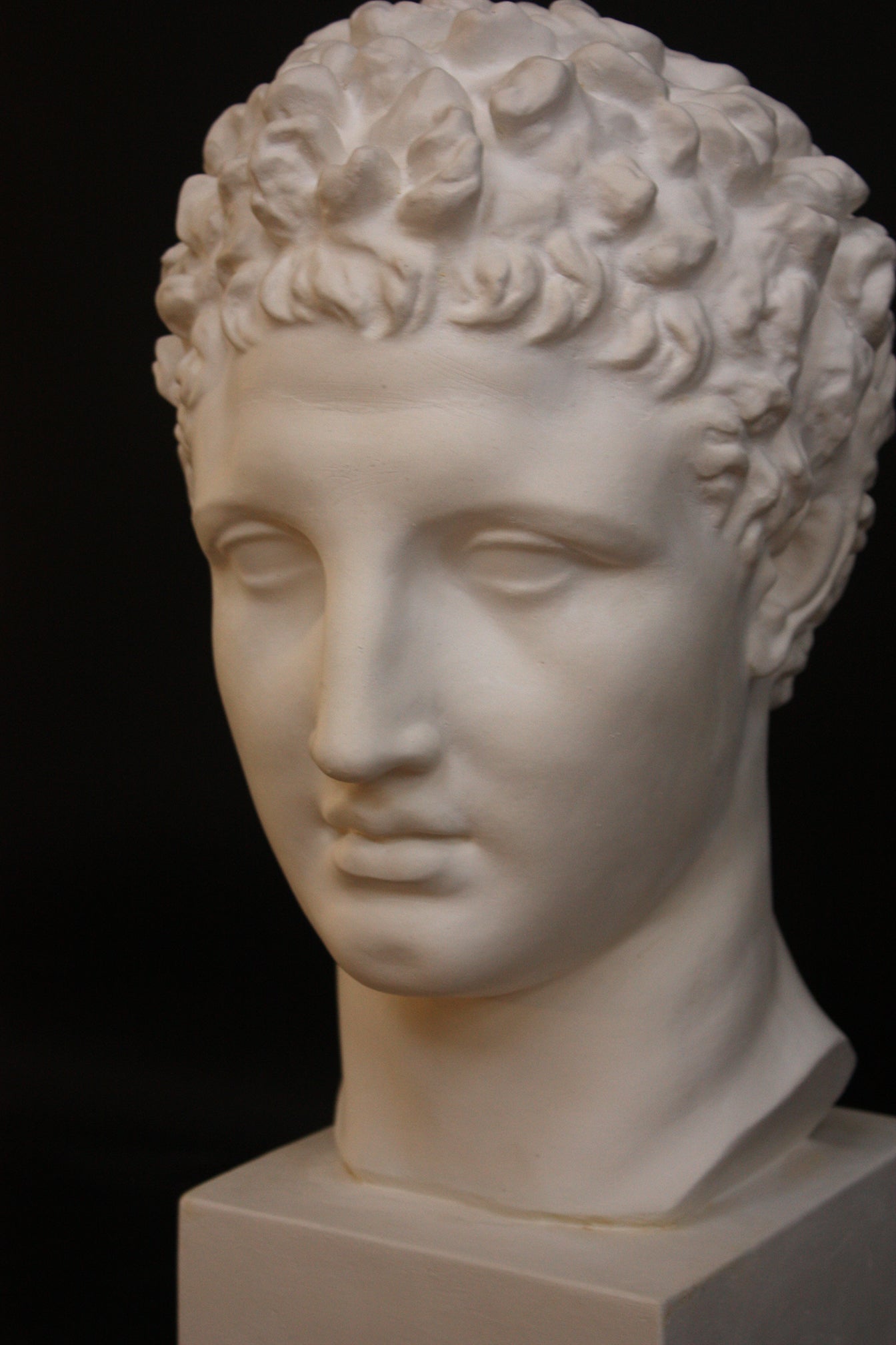 Photo of a sculpture of Hermes head on a black background