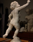 Photo of a sculpture of a cherub on a black background