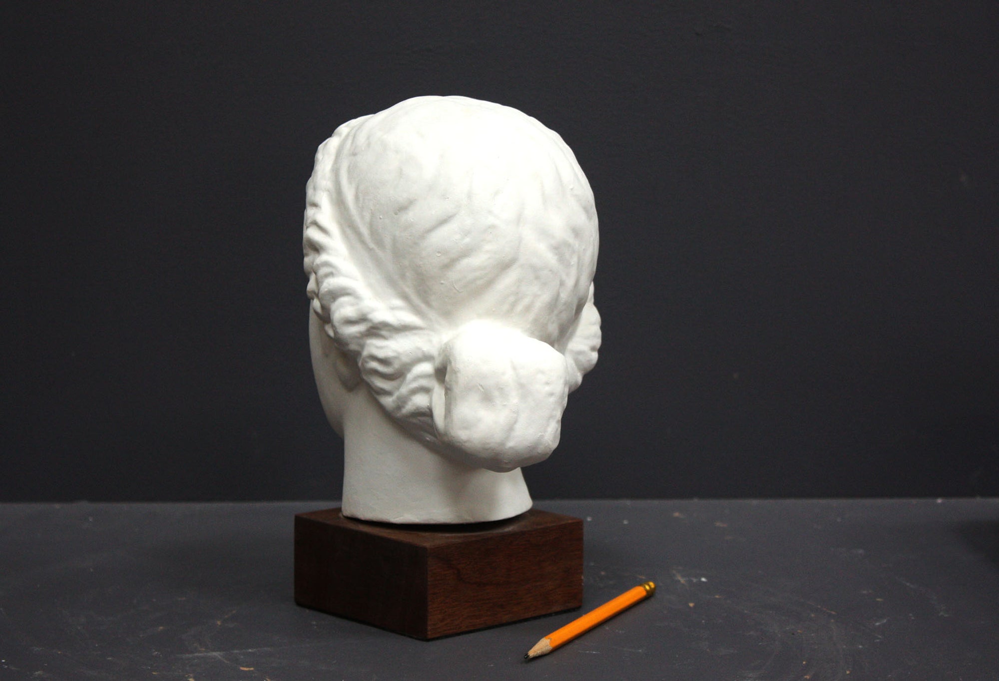 Photo of a sculpture of a female head on a gray background 