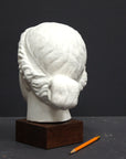 Photo of a sculpture of a female head on a gray background 