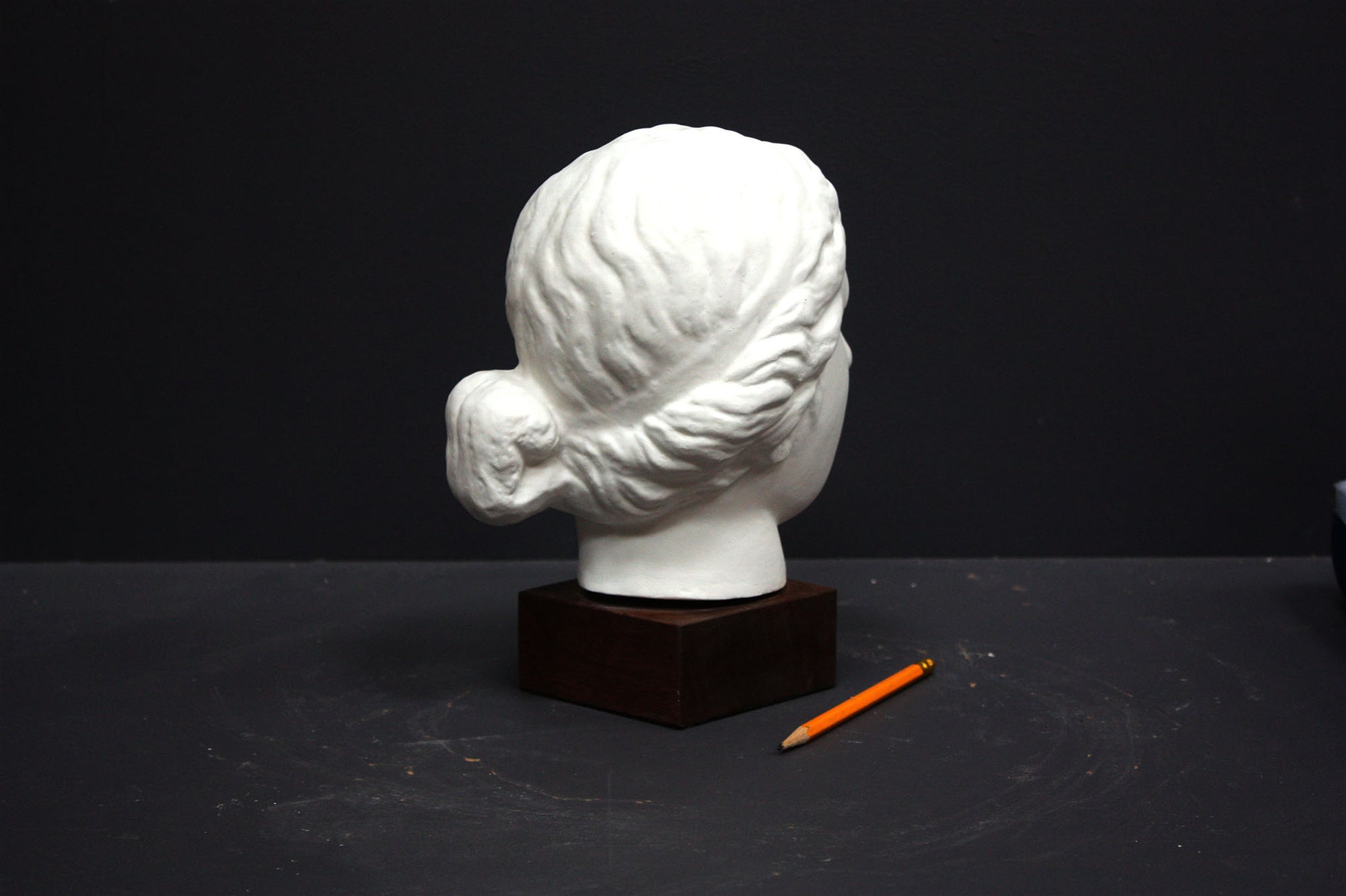Photo of a sculpture of a female head on a gray background 