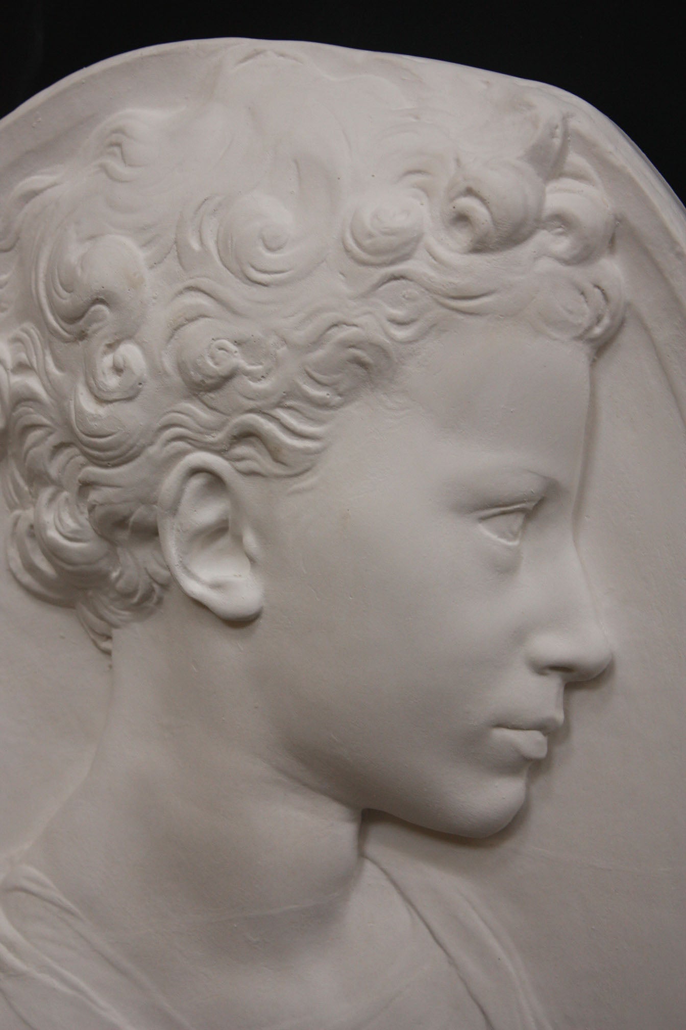Photo of a sculpture of a little girl on a black background