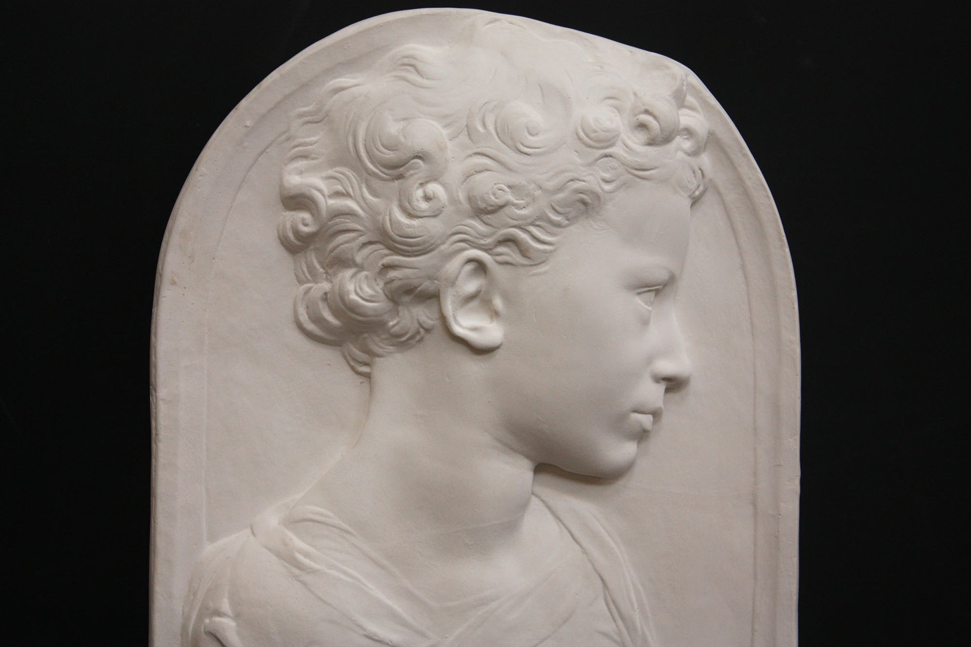 Photo of a sculpture of a little girl on a black background