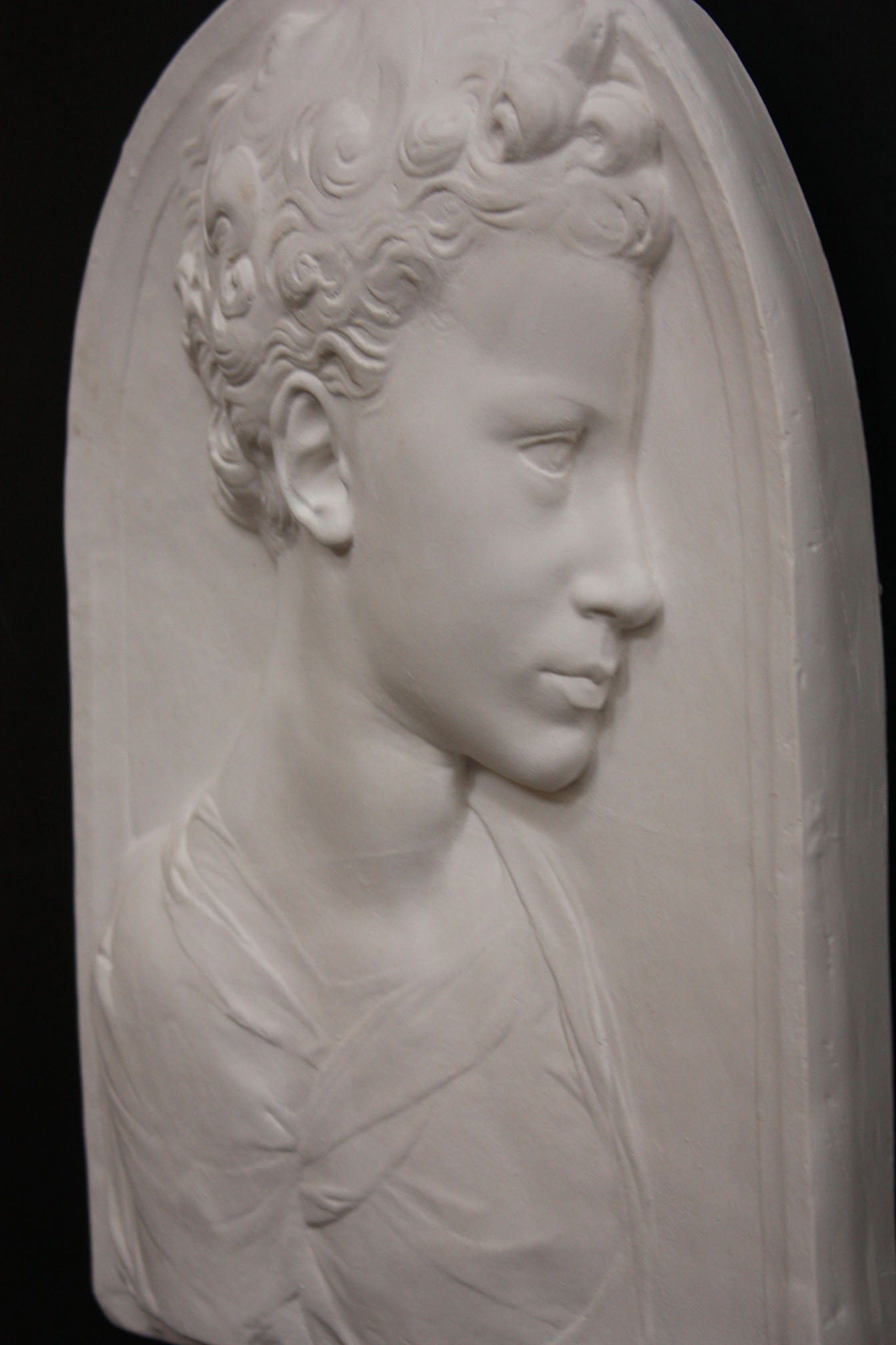Photo of a sculpture of a little girl on a black background