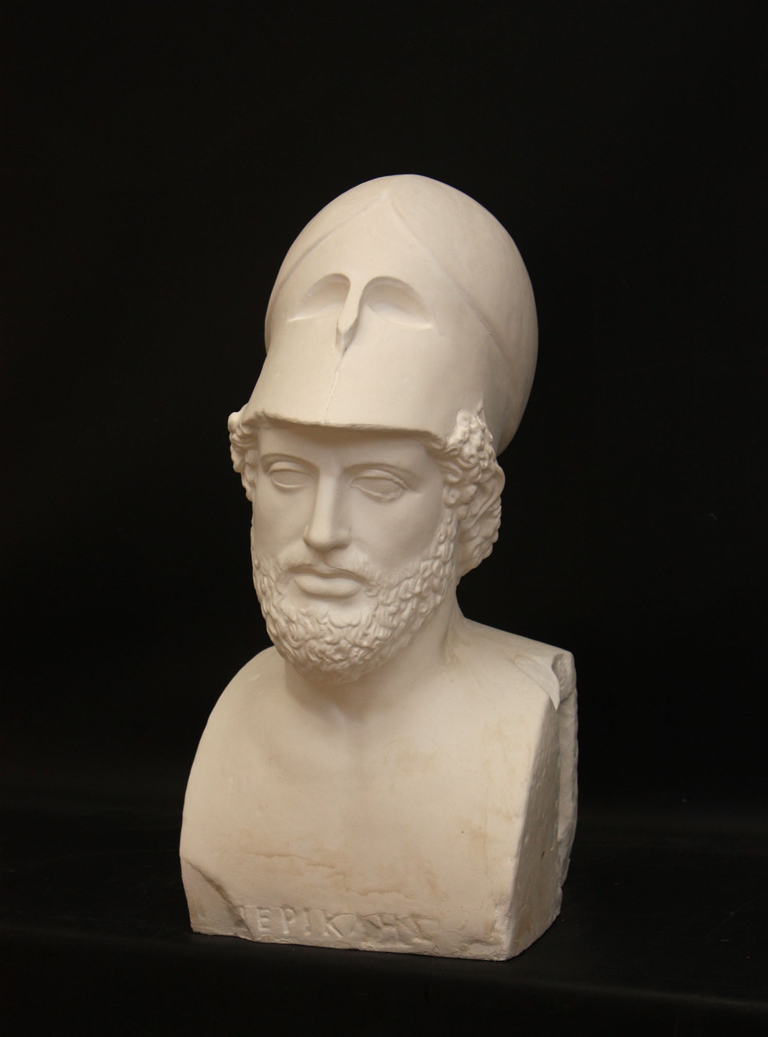 Photo of male sculpture with beard and helmet on a black background