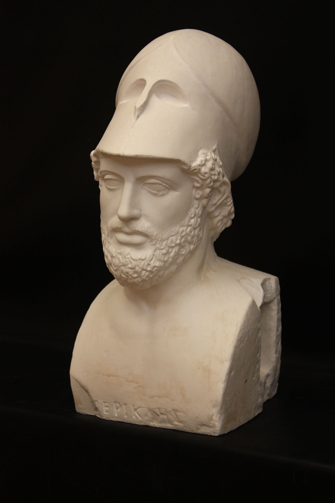 Photo of male sculpture with beard and helmet on a black background