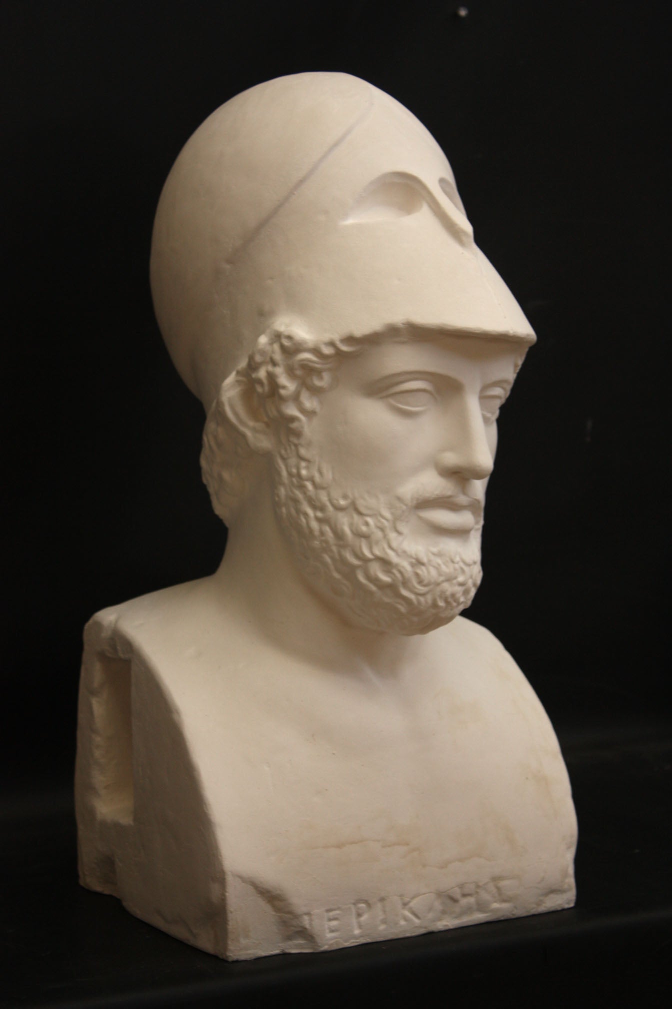 Photo of male sculpture with beard and helmet on a black background
