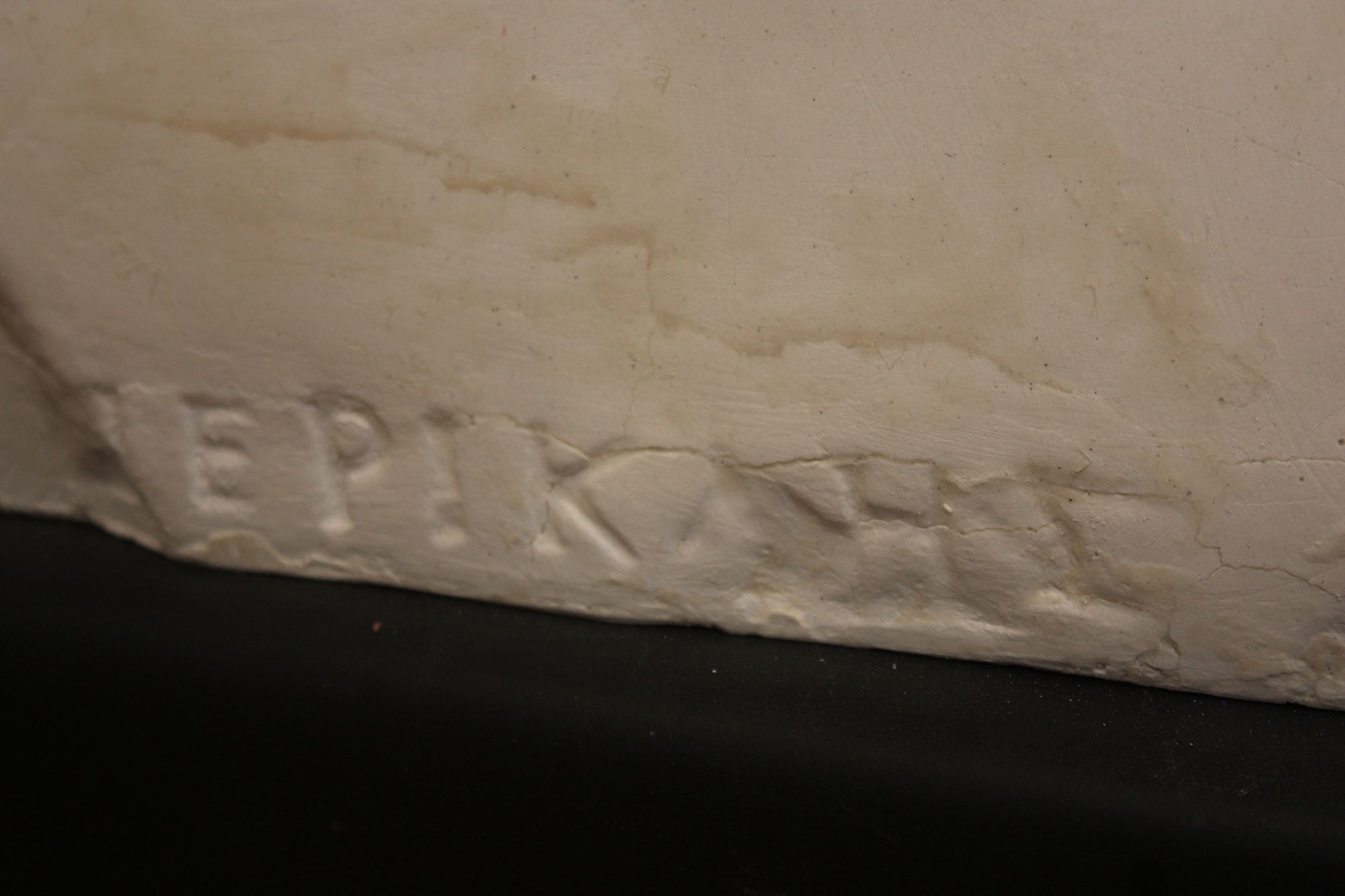 close up photo of a signature on a plaster sculpture