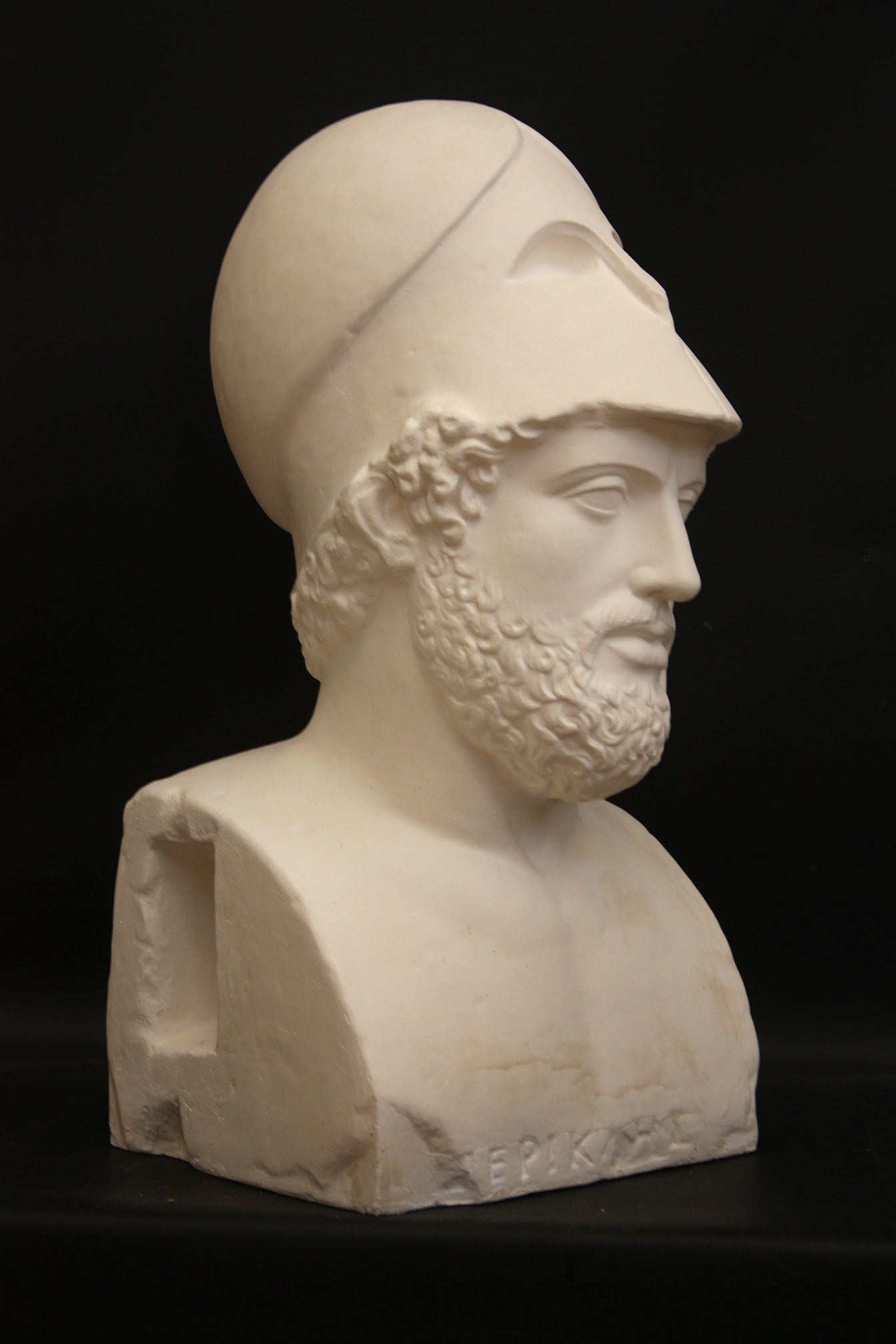 Photo of a sculpture of a man with a beard and a helmet, on a black background
