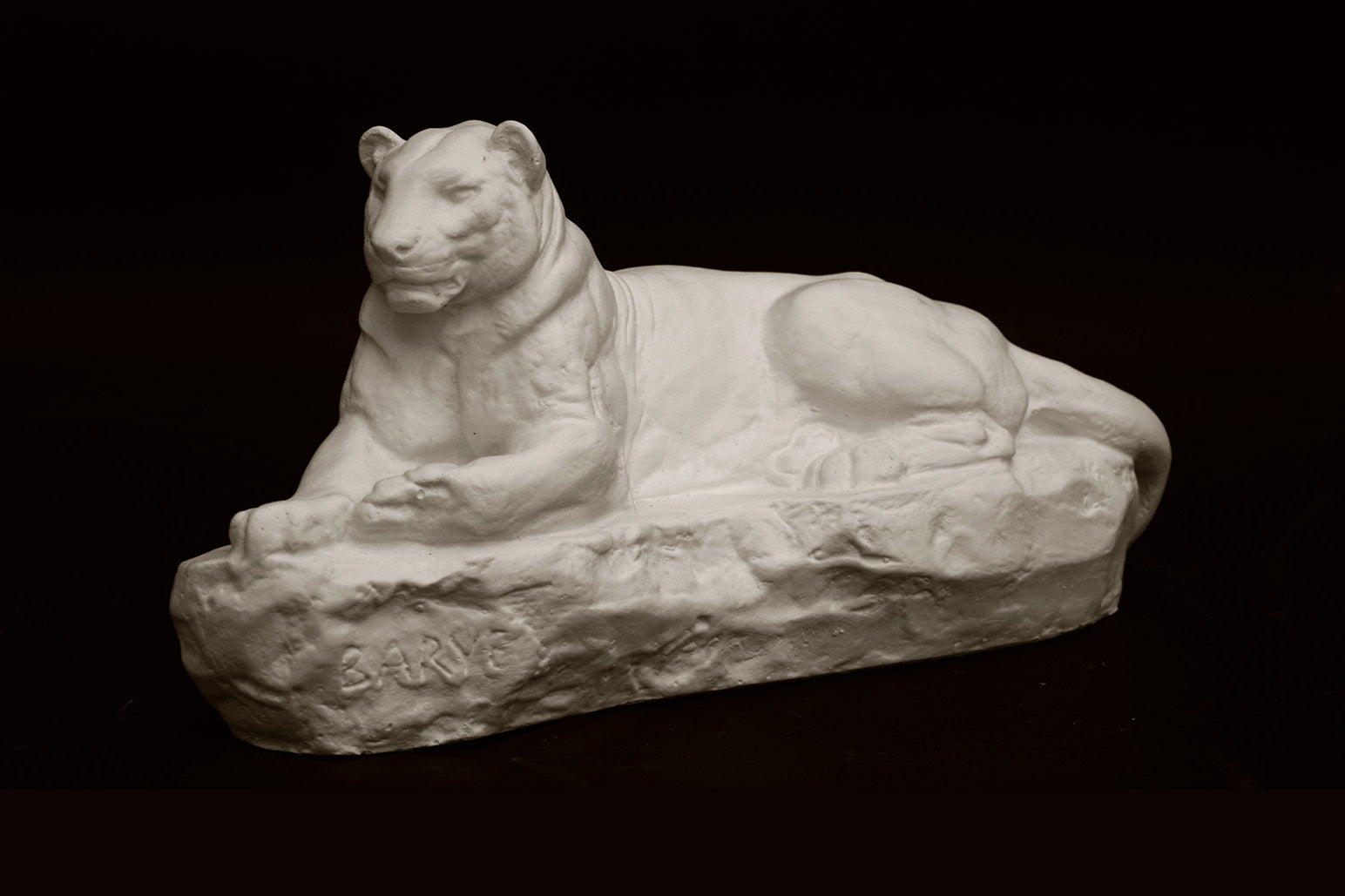 Photo of a sculpture of a Panther reclining on a black background