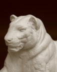 Photo of a sculpture of a Panther reclining on a black background