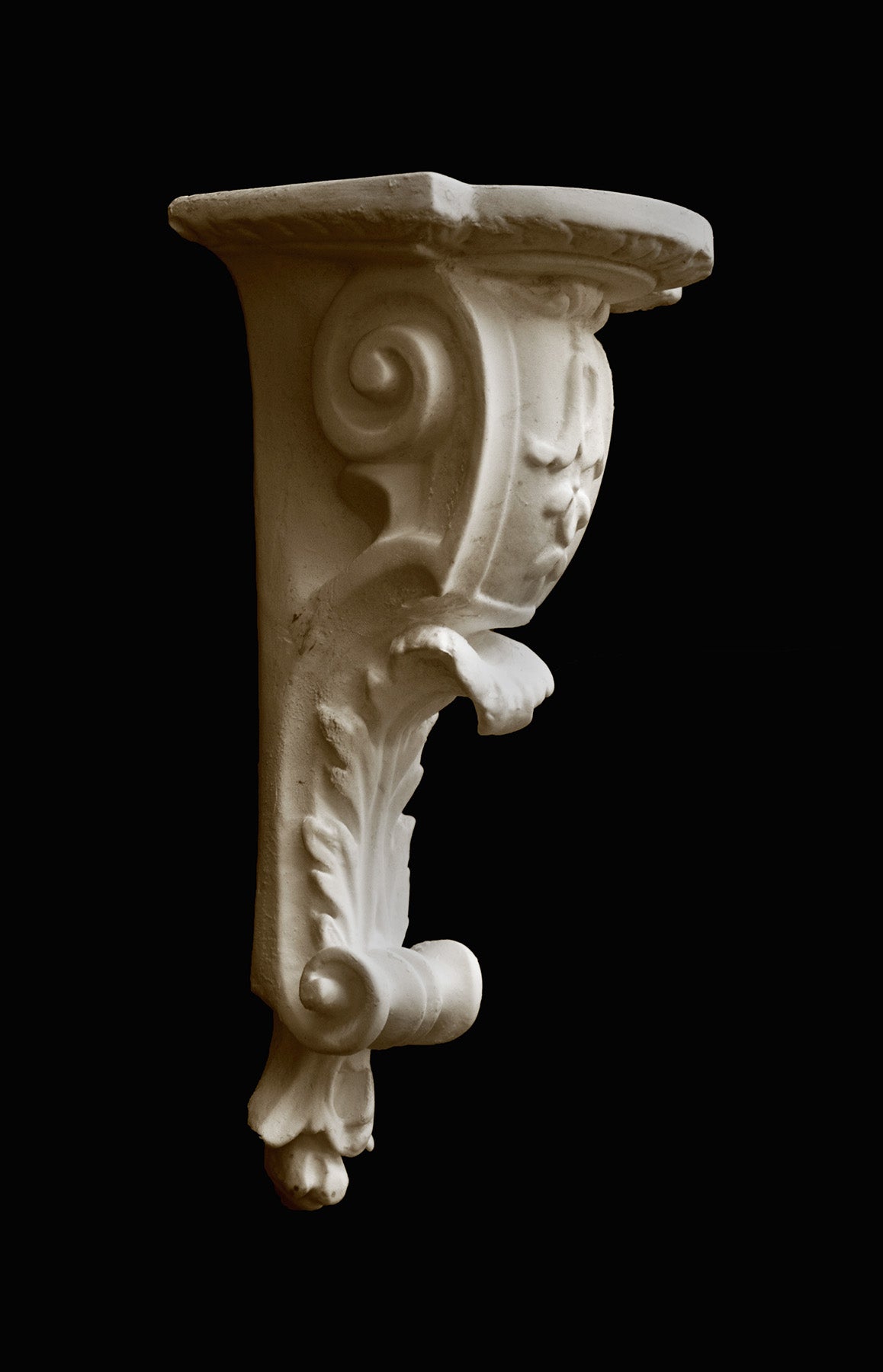 image of a plaster statue of a renaissance bracket on a black background