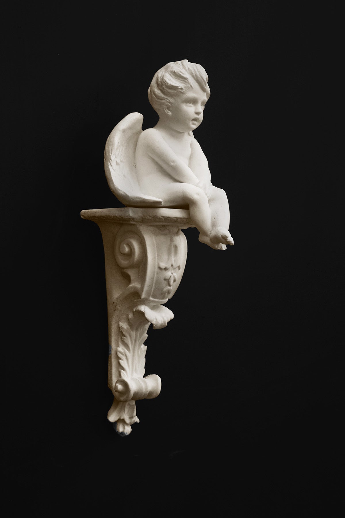 image of a plaster renaissance bracket  with plaster sculpture of angel on a black background