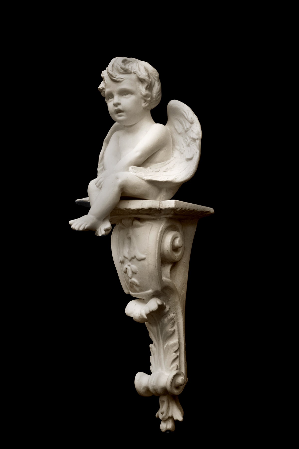 image of a plaster renaissance bracket  with plaster sculpture of angel on a black background