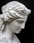 detail photo of plaster cast of sculpture bust of Ariadne or Bacchus with long, curly hair and head band on a gray background