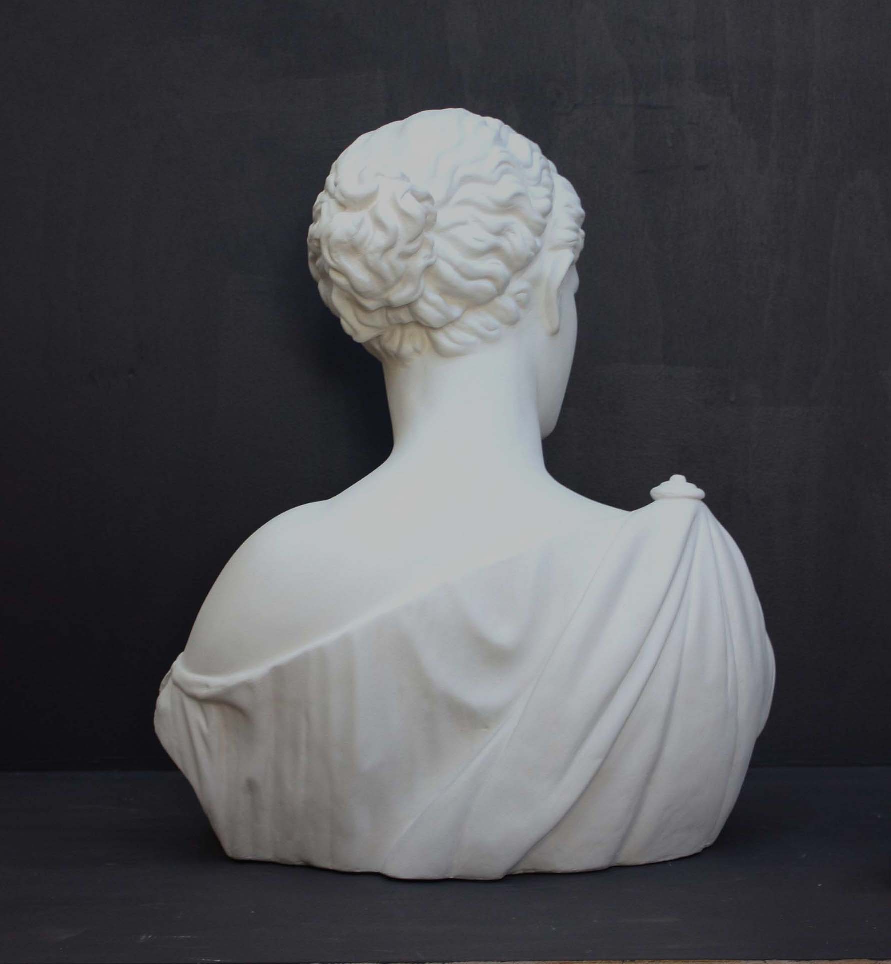 photo of plaster cast of ancient female bust, namely the goddess Diana, with a grey background