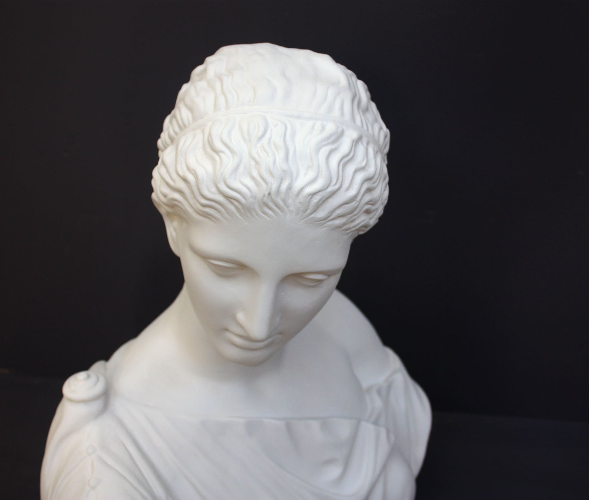 photo of plaster cast of ancient female bust, namely the goddess Diana, with a grey background