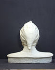 photo of plaster cast bust sculpture of Dante Alighieri with cap and high-necked robe with red book leaning against right side on black background