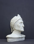 photo of plaster cast bust sculpture of Dante Alighieri with cap and high-necked robe with red book leaning against right side on black background