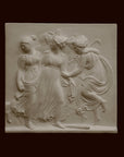 Photo with black background of plaster cast sculpture relief of females dancing