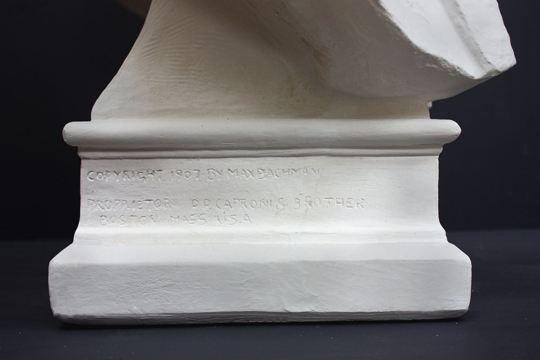 detailed image of a plaster statue of a bust of lincoln on a gray background 