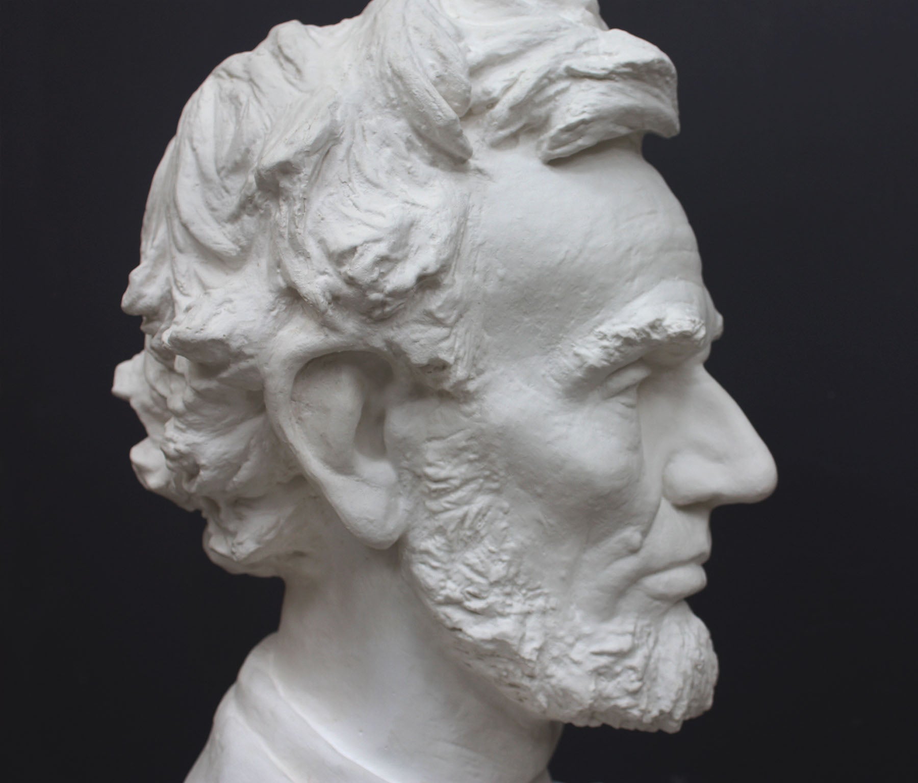 image of a plaster statue of a bust of lincoln on a gray background