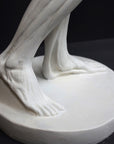 photo of plaster cast sculpture of flayed male figure study with right arm outstretched and left arm down on a gray background