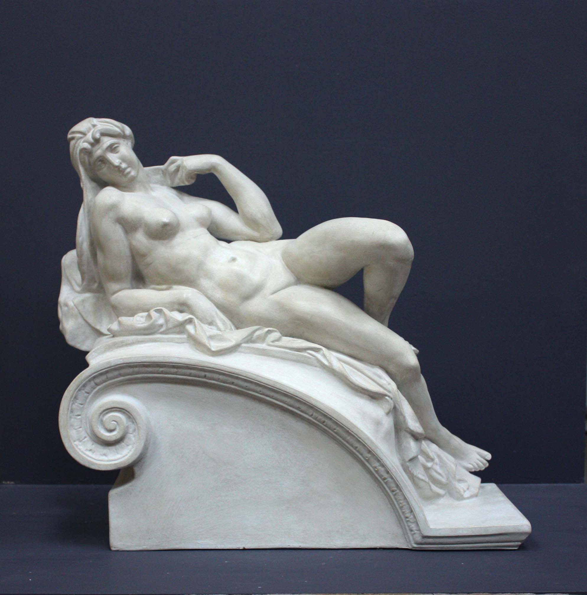 photo of a sculpture of a reclining nude female on a grey background