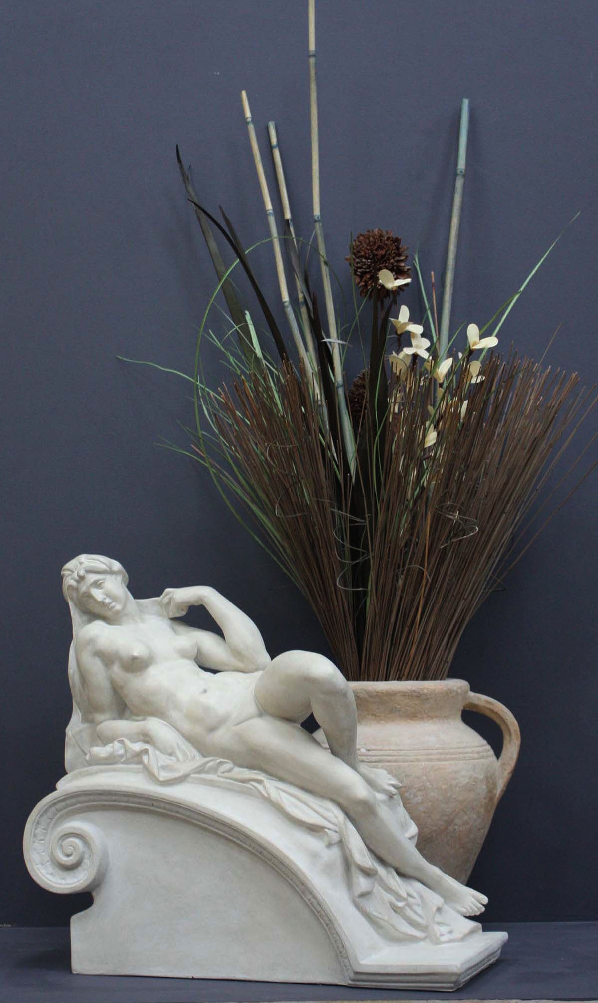 photo of a sculpture of a reclining nude female on a grey background