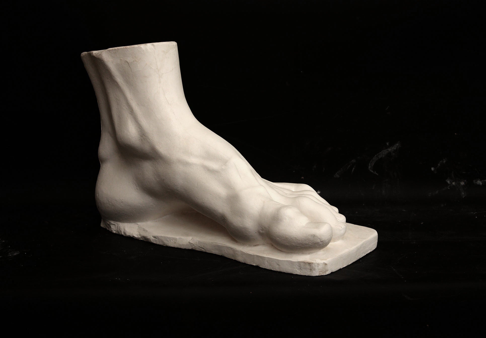 photo of a sculpture of a foot on a black background