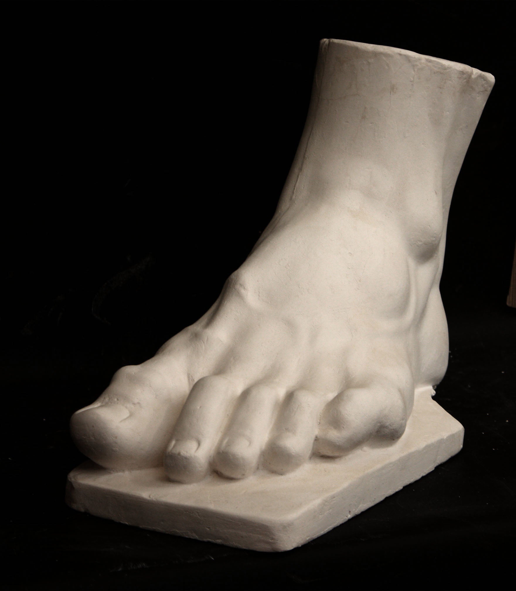 photo of a sculpture of a foot on a black background
