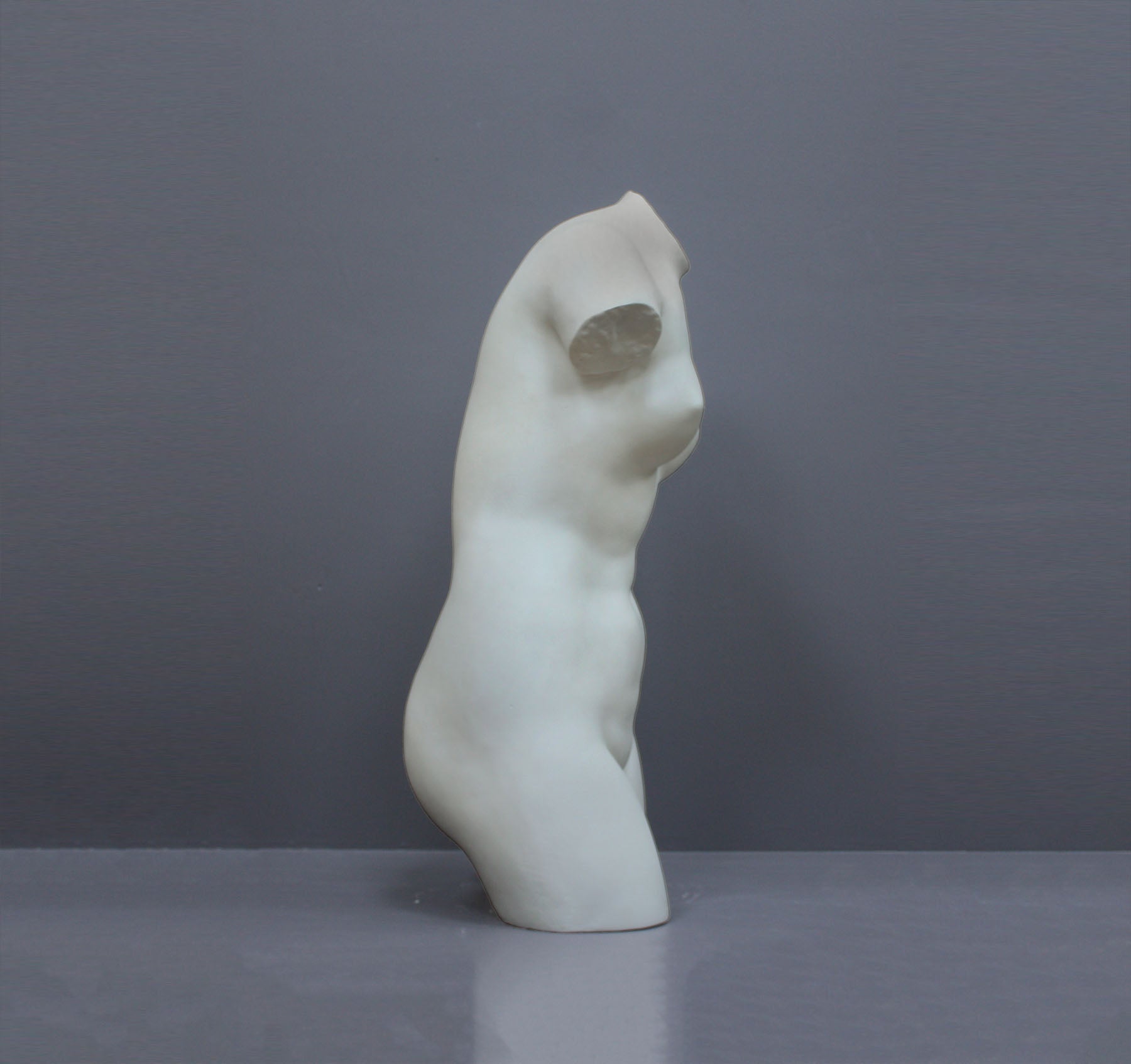 Image of a plaster statue as a bust of venus on a grey background