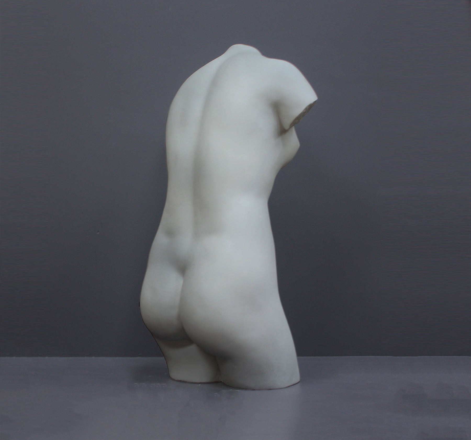 Image of a plaster statue as a bust of venus on a grey background