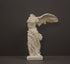 photo of plaster cast sculpture of winged, headless female figure with flowing drapery on a gray background