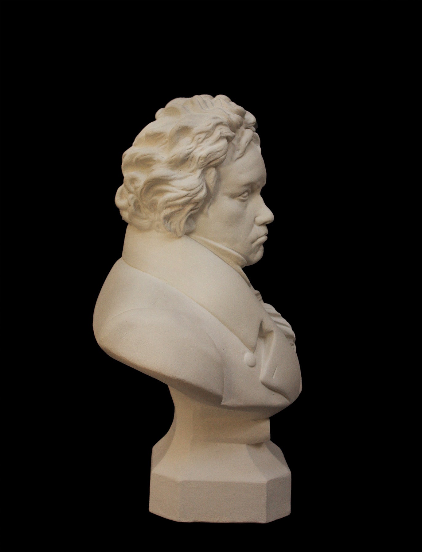 photo of plaster cast sculpture of male bust of Ludwig van Beethoven in dress coat and ruffled necktie on black background