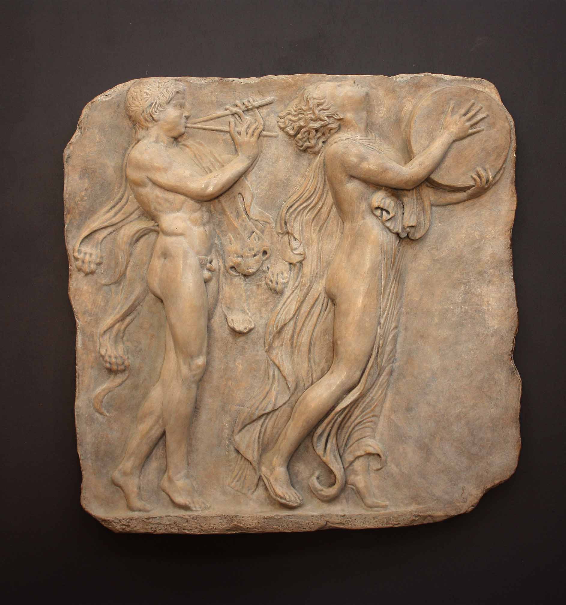 Photo of sculpture of 2 figures marching with musical instruments on a black background
 