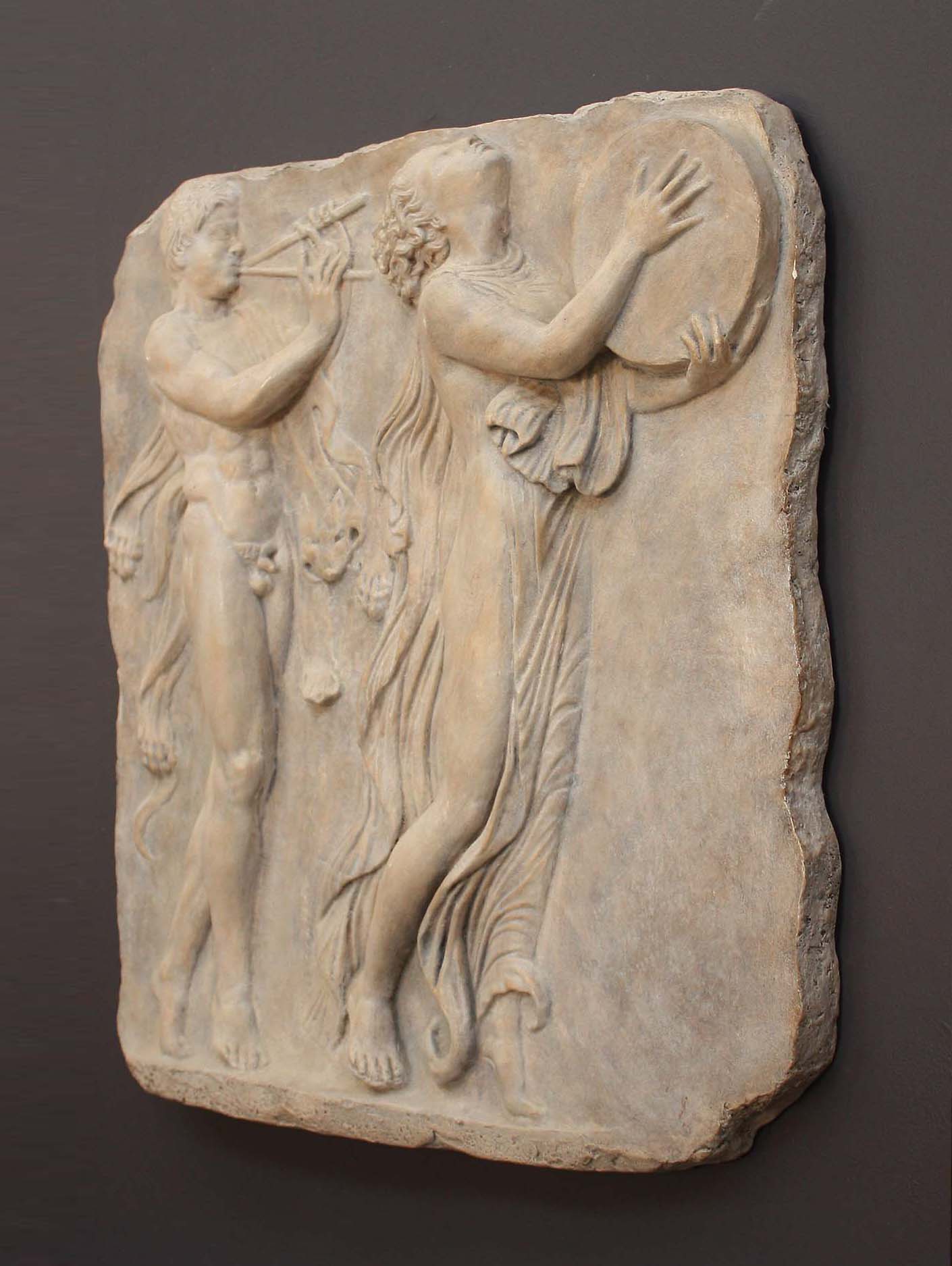 Photo of sculpture of 2 figures marching with musical instruments on a black background