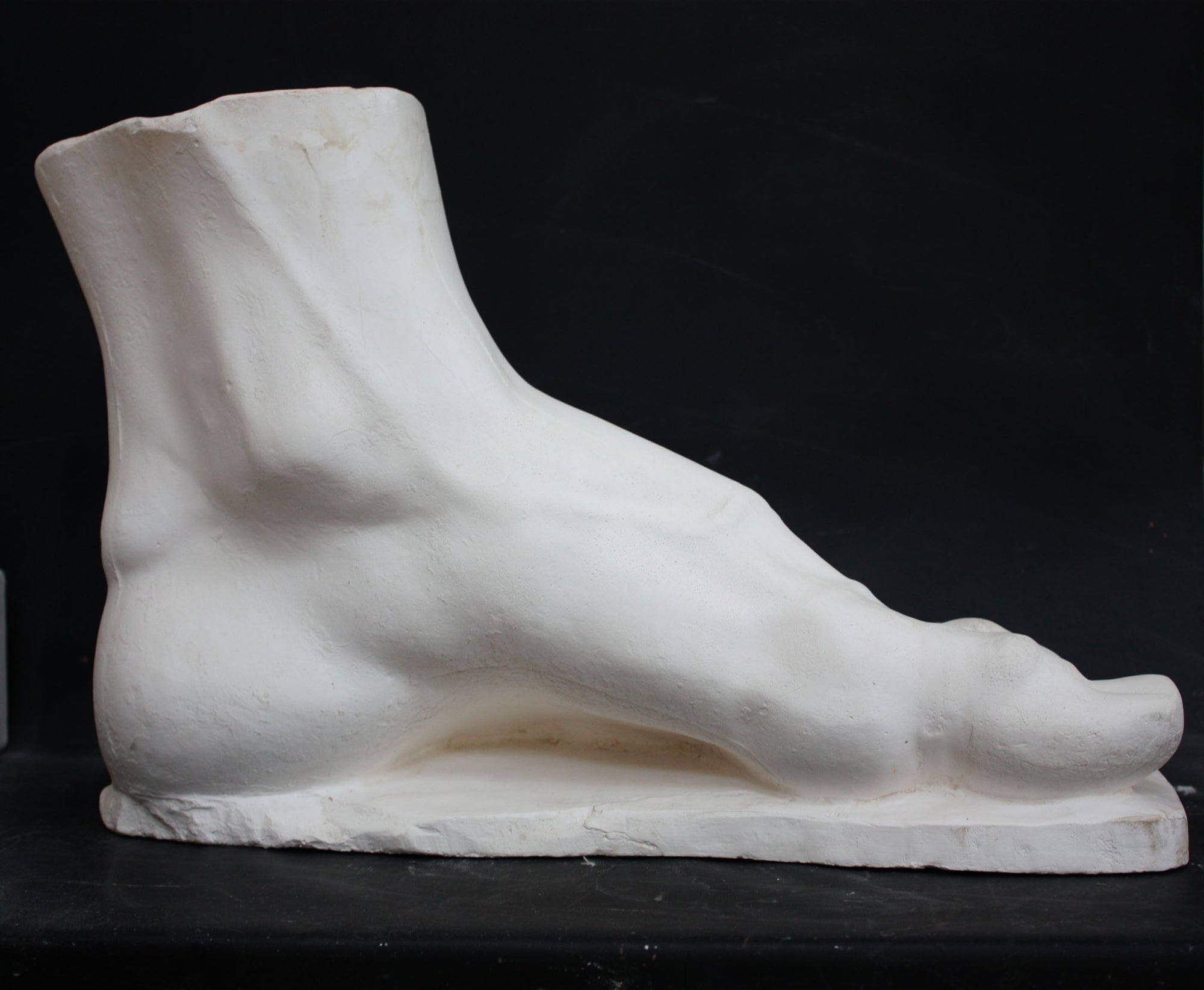 photo of a sculpture of a foot on a black background