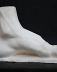 photo of a sculpture of a foot on a black background