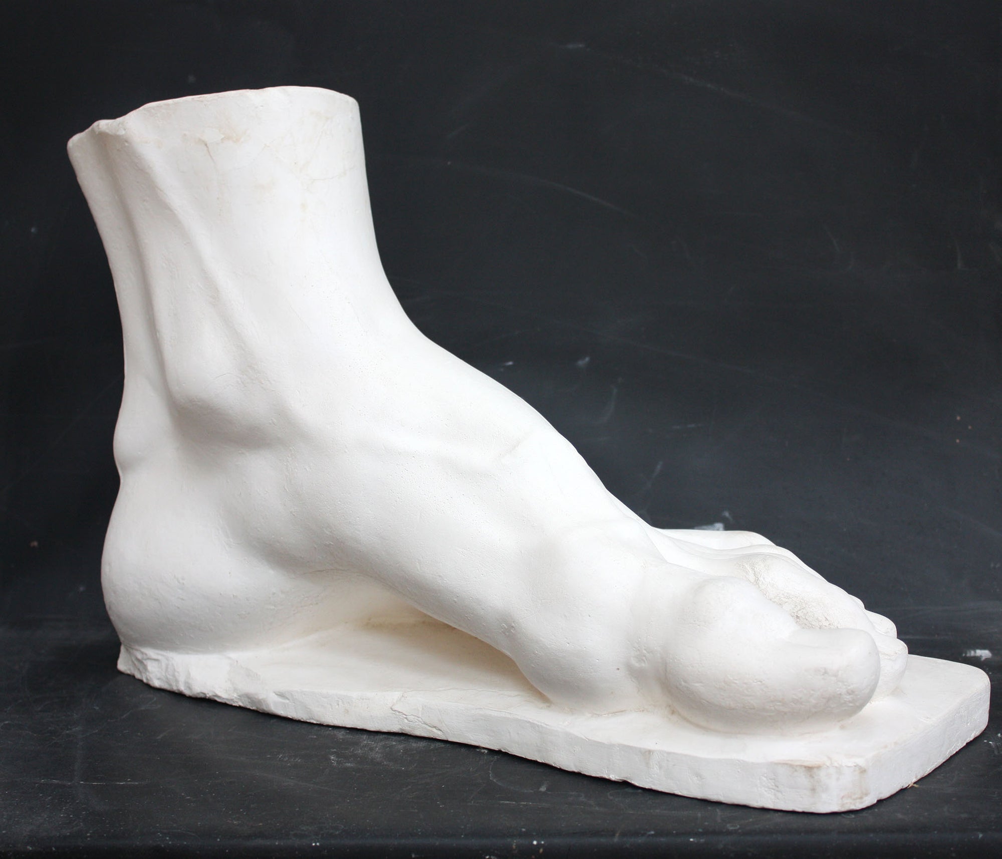 photo of a sculpture of a foot on a black background