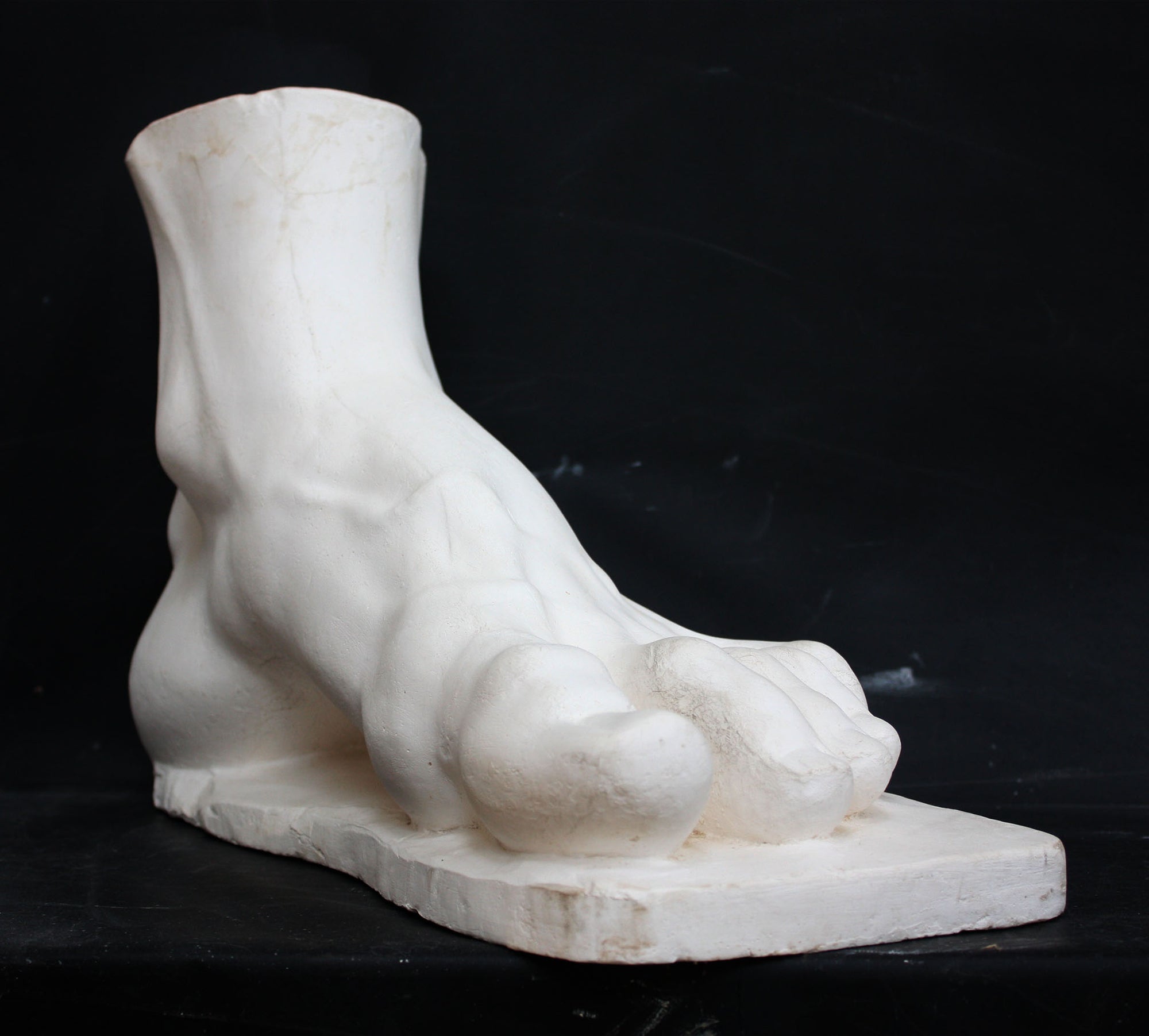 photo of a sculpture of a foot on a black background