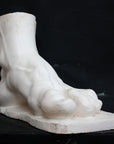 photo of a sculpture of a foot on a black background