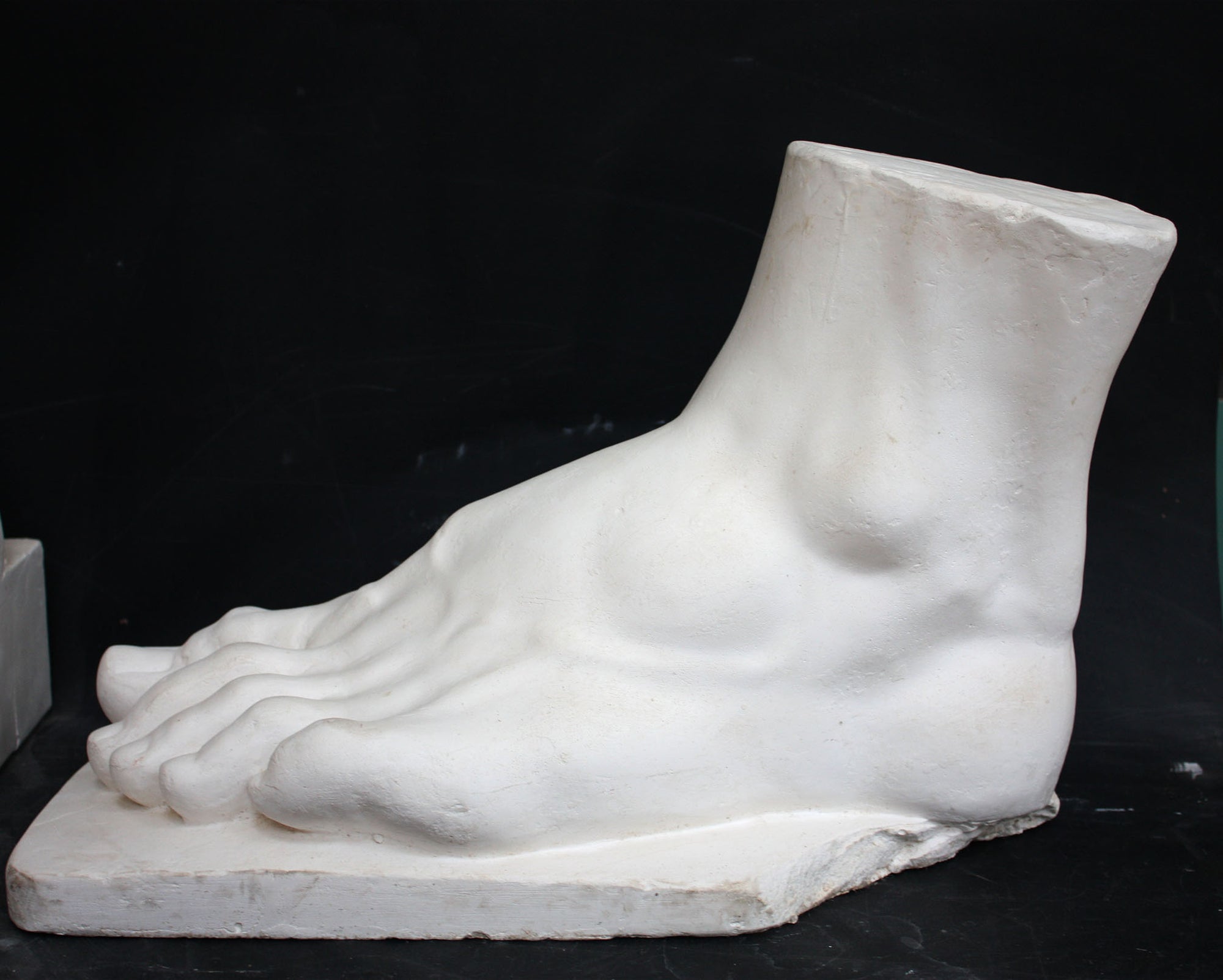 photo of a sculpture of a foot on a black background
