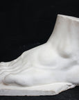 photo of a sculpture of a foot on a black background