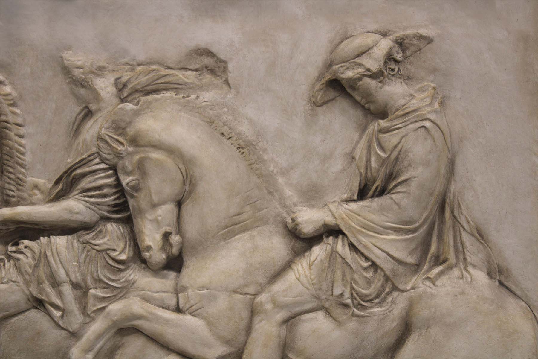 detail photo of off-white plaster cast relief sculpture of two men on horseback from Parthenon 