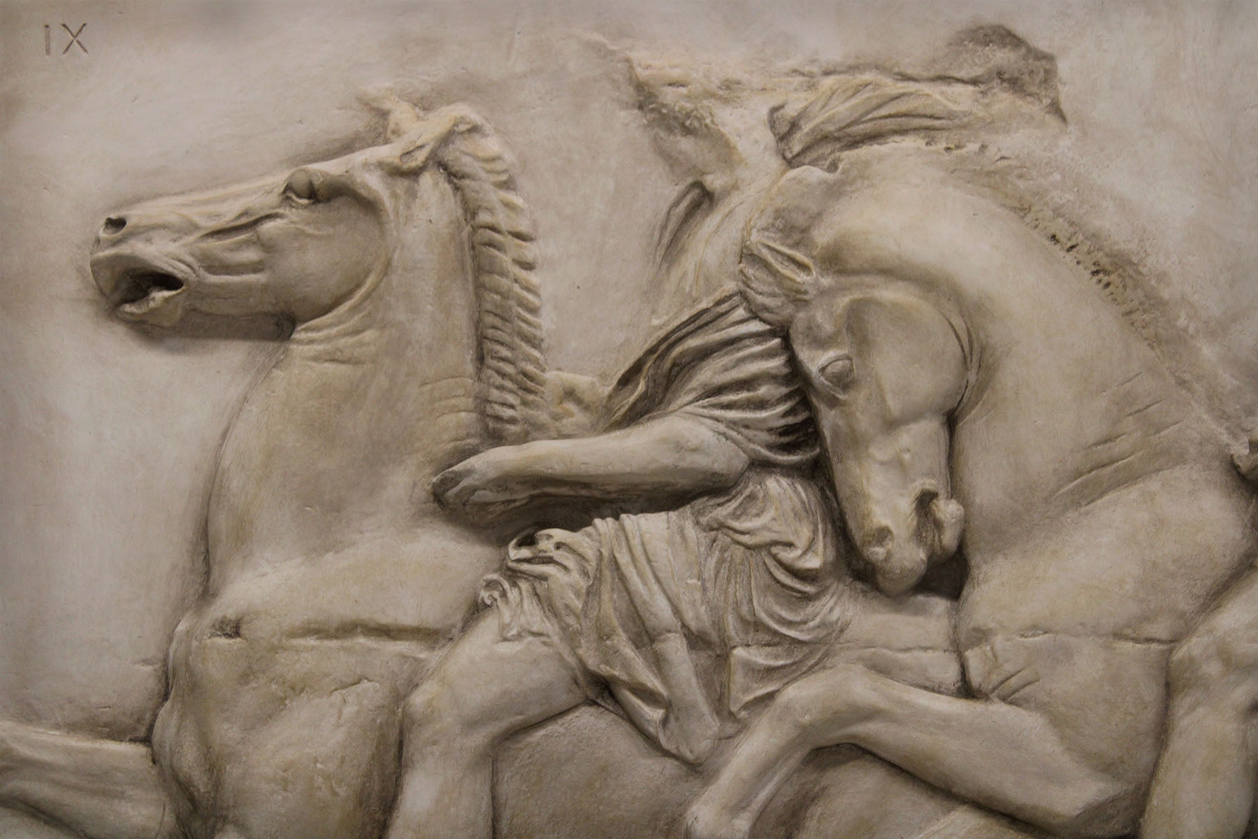 detail photo of off-white plaster cast relief sculpture of two men on horseback from Parthenon
